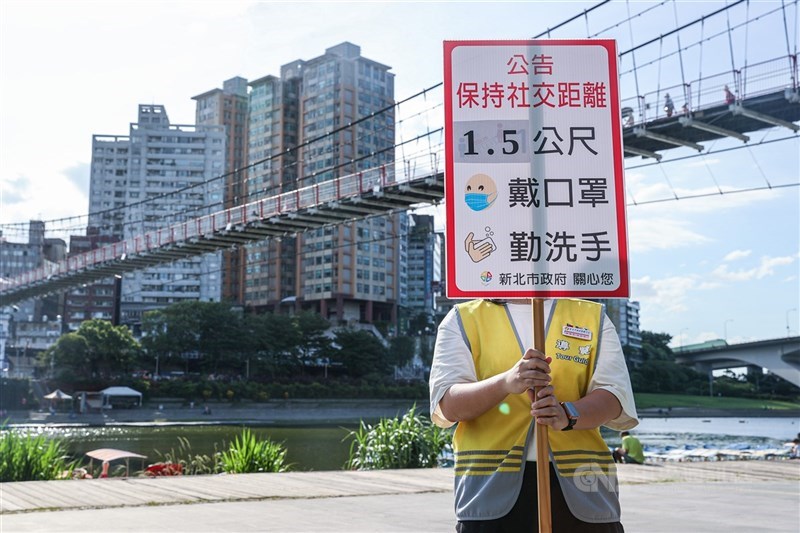 微解封後第一個週末假期,新店碧潭一帶17日遊客不多,新北碧潭風景區有人員在場舉牌,持續提醒民眾遵守防疫相關規定。中央社記者鄭清元攝 110年7月17日