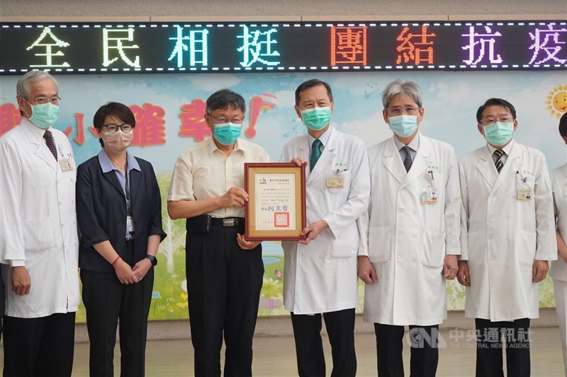 台北榮民總醫院在COVID-19疫情嚴峻時,支援北市府於北農、環南市場進行大規模PCR篩檢,台北市長柯文哲(左3)、副市長黃珊珊(左2)19日上午前往北榮頒發感謝狀,由北榮院長許惠恒(右3)代表接受。中央社記者徐肇昌攝 110年7月19日