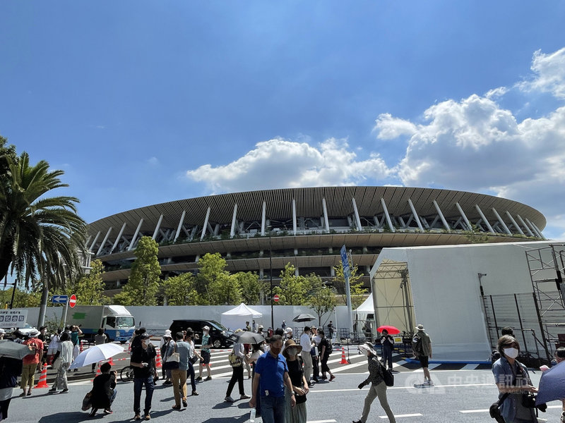 東京奧運主場館國立競技場23日有很多民眾前來觀賞日本航空自衛隊飛行表演隊藍色衝擊波的表演,並拍照留念。中央社記者楊明珠東京攝 110年7月23日