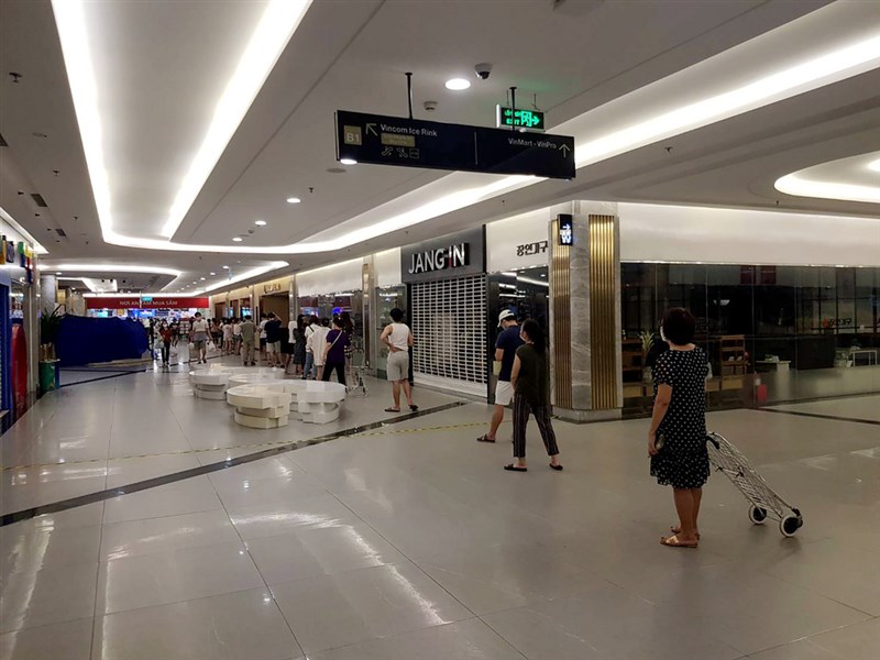 越南胡志明市全市自9日起實施15天社交距離措施,民眾除非必要不准外出。圖為胡志明市11日一家商場內只剩超市還開著,民眾正排隊等待入內消費。(讀者提供)