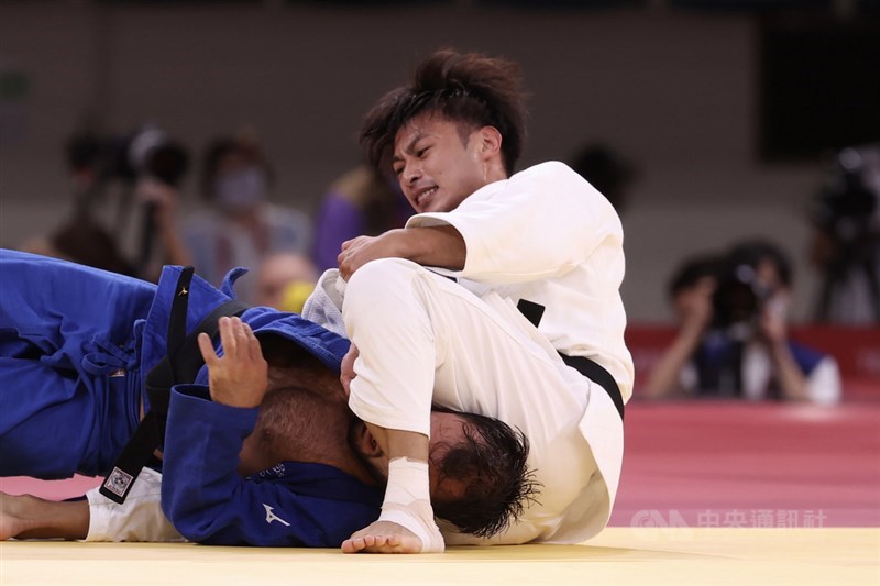 楊勇緯（白衣）在4強戰與法國對手纏鬥許久，最終成功壓制對手奪勝。中央社記者吳家昇攝 110年7月24日