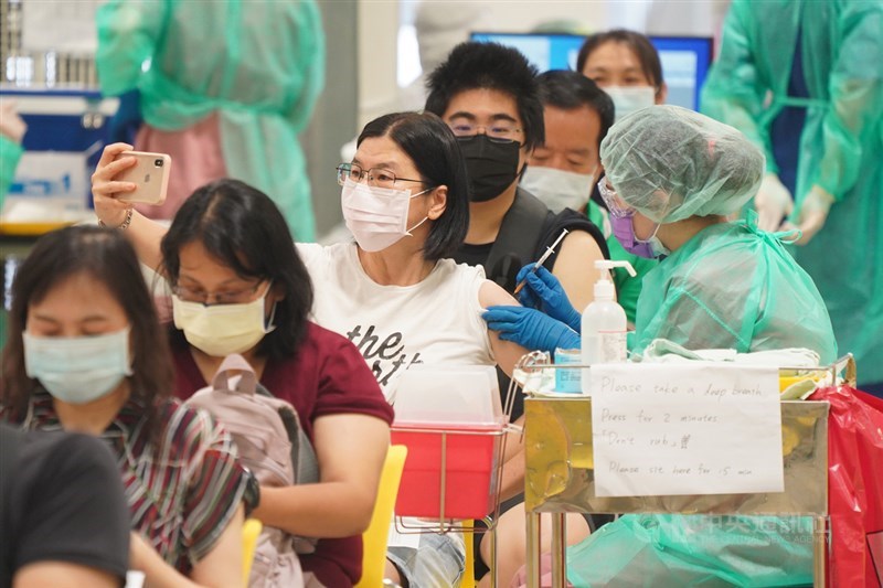 中央流行疫情指揮中心公布,23日接種逾25萬劑疫苗,疫苗人口涵蓋率達26%。圖為接種者拿起手機自拍留念。(中央社檔案照片)