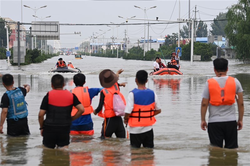 河南洪災罹難人數持續上升,截至25日中午12時全省達63人死亡、5人失蹤,1144.78萬人受災,鄭州、新鄉、鶴壁、開封等6個地級市成重點救災區域。圖為救援人員25日在河南新鄉協助災民撤離。(中新社)