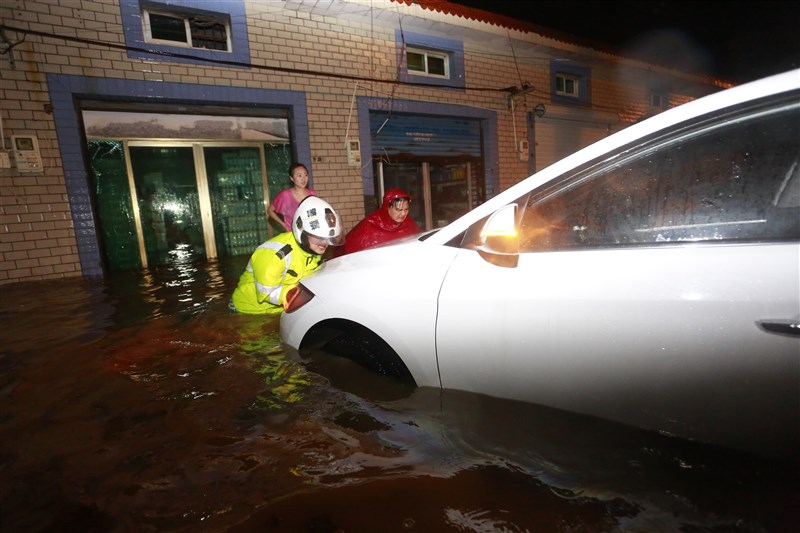 暴雨造成中國河南省嚴重災情,中國氣象台預報,25、26日兩天中國浙江、上海、安徽、內蒙等地也將出現暴雨。圖為浙江舟山省交警25日幫民眾將泡水車輛推到安全區域。(中新社)