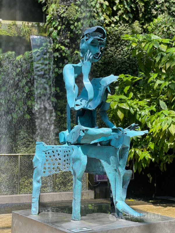 新加坡濱海灣花園雲霧林展出台灣雕塑家李光裕的作品,「思惟」這件作品(圖)與流動的瀑布形成強烈對比,新加坡總理李顯龍也曾PO文分享。攝於7月22日。中央社記者侯姿瑩新加坡攝 110年7月26日