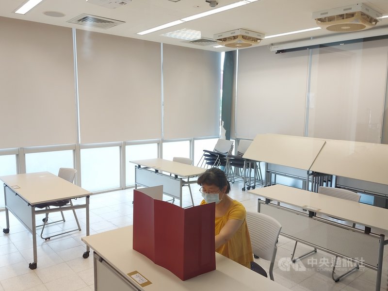 110學年度指定科目考試將於28日登場,台大分區27日下午開放身心障礙考生查看試場,圖為工作人員示範中午用餐時在座位上架設用餐隔板。中央社記者許秩維攝 110年7月27日
