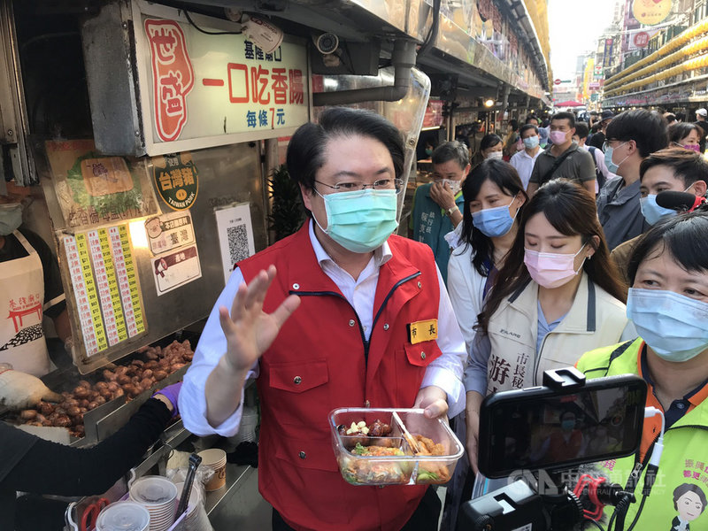 基隆廟口夜市27日起恢復營業,市長林右昌(左)下午前往廟口宣導「加強版十大防疫指引」,並自備餐盒買小吃,他鼓勵消費者自帶餐具,不僅環保也能防疫。中央社記者王朝鈺攝 110年7月27日