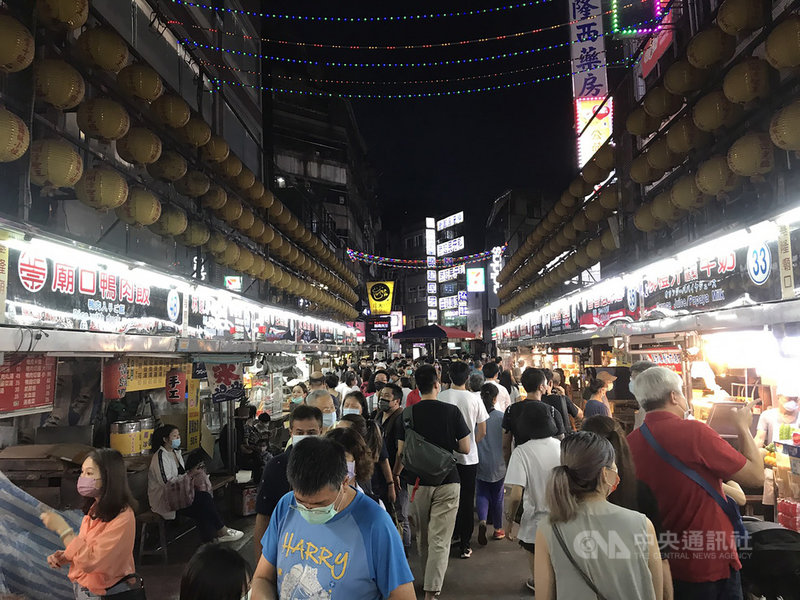 全台疫情警戒降級,基隆廟口及愛四路夜市27日復市,晚間湧入許多人潮,市府呼籲民眾到夜市仍需做好防疫,需遵守各項防疫指引,包括全程配戴口罩、不得邊走邊吃等。中央社記者王朝鈺攝 110年7月27日