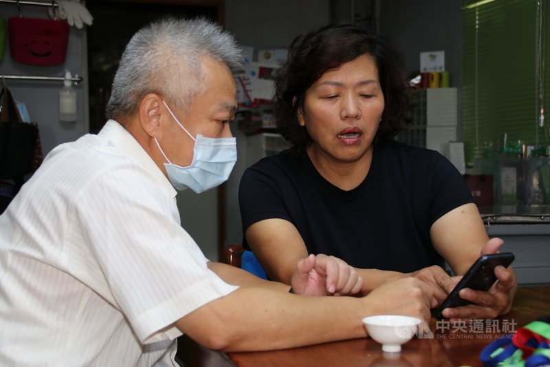 台灣射擊選手楊昆弼28日出戰東京奧運男子不定向飛靶資格賽,楊昆弼母親高明雪(右)透過手機了解即時得分。中央社記者蕭博陽彰化縣攝 110年7月28日