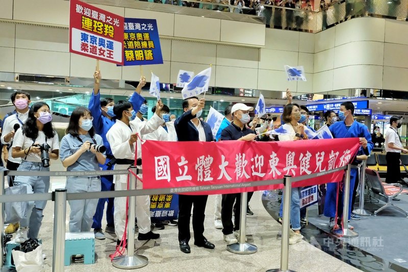 台灣東奧柔道、跆拳道、輕艇及舉重代表隊28日搭機從日本東京載譽歸國,「柔道男神」楊勇緯的學弟妹特別到桃園機場接機,高舉歡迎布條。中央社記者吳睿騏桃園機場攝 110年7月28日