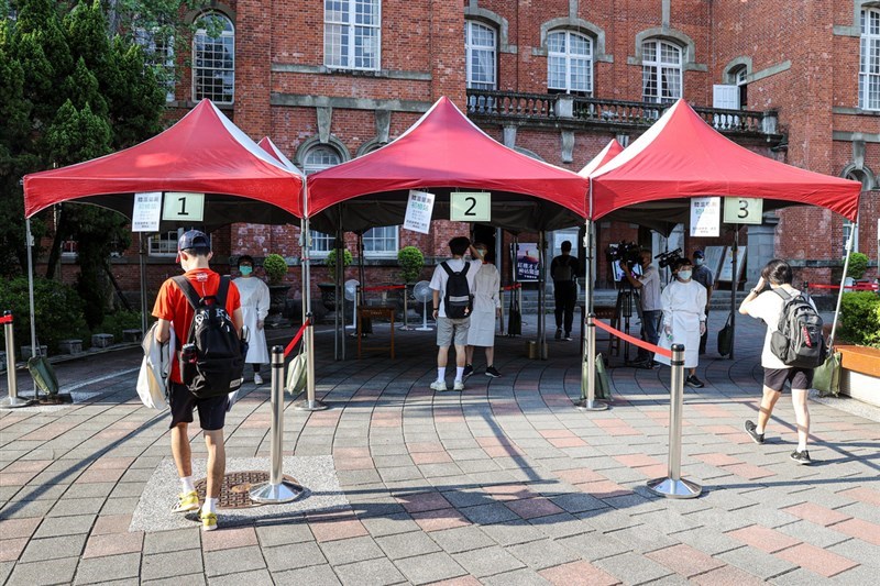 因COVID-19疫情延後的110學年度指定科目考試28日登場,考生進場前,分流排隊測量體溫。中央社記者鄭清元攝 110年7月28日
