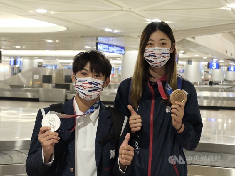 台灣東奧柔道、跆拳道、輕艇及舉重代表隊28日下午搭機從日本東京載譽歸國,獲得柔道銀牌的楊勇緯(左)與拿下跆拳道銅牌的羅嘉翎(右)成為焦點。中央社記者吳睿騏桃園機場攝 110年7月28日