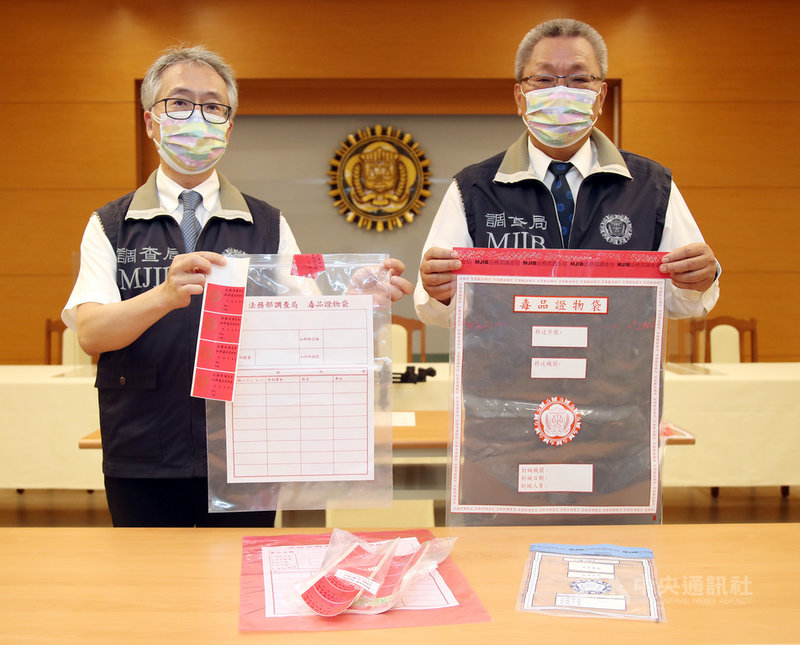 調查局28日表示,所有毒品案件納入「犯罪調查作業系統」以管制案件進度,調查局毒品防制處長蔡文郎(右)展示,調查局最新採購具「防拆密封條」專利的毒品證物袋(紅色袋),供外勤處站查獲第3、4級毒品鑑驗後封緘使用。中央社記者張新偉攝 110年7月28日