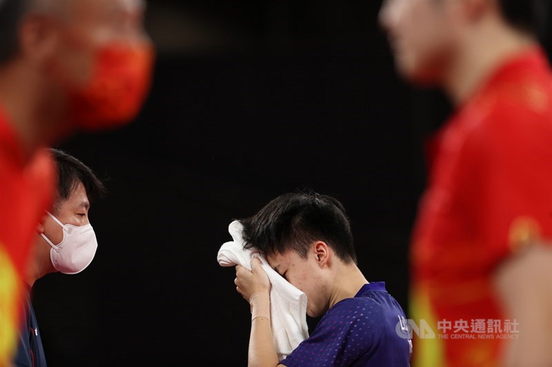 台灣桌球好手林昀儒(後)29日下午在東京奧運桌球男子單打4強戰遇上中國頭號種子樊振東,雙方激戰7局,彼此一路緊咬,終場林昀儒以3比4飲恨落敗。圖為林昀儒在場邊擦拭汗水。中央社記者吳家昇攝 110年7月29日