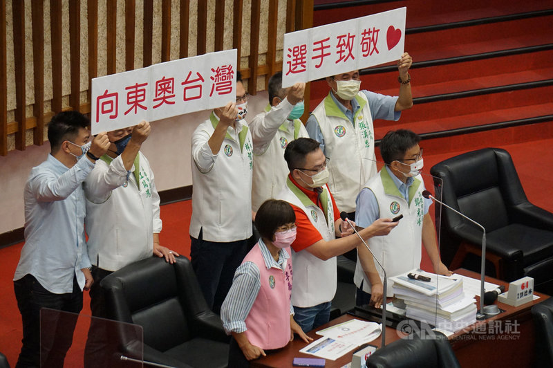 高雄市議會29日進行市政總質詢,市議員手持「向東奧台灣選手致敬」標語(圖),建議將「奧運績優獎助金」金牌提高為新台幣150萬元。市長陳其邁說,會與選手職涯照顧一併研議。中央社記者蔡孟妤攝 110年7月29日