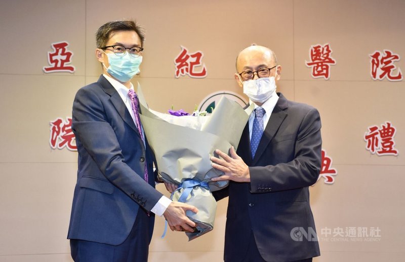 新北市板橋亞東紀念醫院新任院長邱冠明(左)29日接任,並獻花給卸任院長林芳郁(右)。(亞東紀念醫院提供)中央社記者黃旭昇新北傳真 110年7月29日