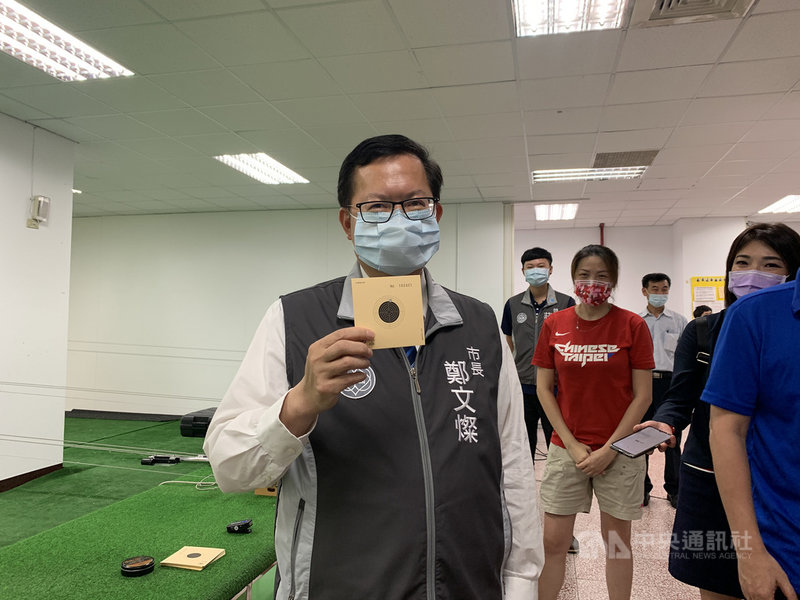 桃園市長鄭文燦(中)30日到南崁高中關注東奧射擊女子25公尺火藥手槍決賽,隨後也在校內射擊練習場「小試身手」,他持步槍射擊時僅一發就打中靶心,但手槍時失手沒中靶,則苦笑「還要再回夜市練習」。中央社記者葉臻攝 110年7月30日