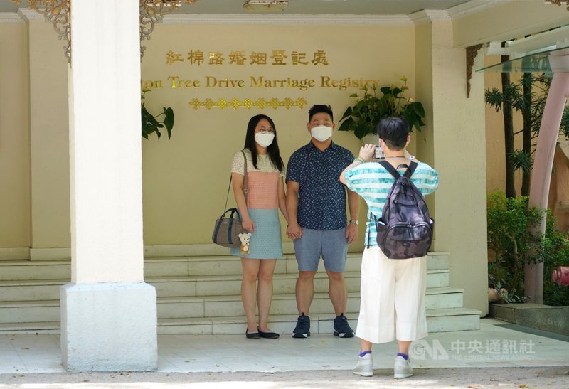 官方統計顯示,2019冠狀病毒疾病(COVID-19)的爆發導致香港2020年的結婚率大幅下降37%。圖為去年農曆七夕,有新人來到香港紅棉路婚姻登記處,並在登記處門口拍照留念。(香港中通社提供)中央社 110年7月30日