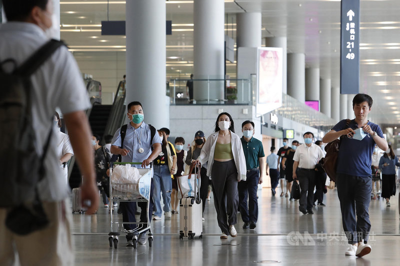 中國疫情管制回歸常態半年後,計劃移民的「潤學」並沒有停止,許多中產家長寄望在孩子身上。圖為上海虹橋國際機場旅客推著行李。(中新社)
