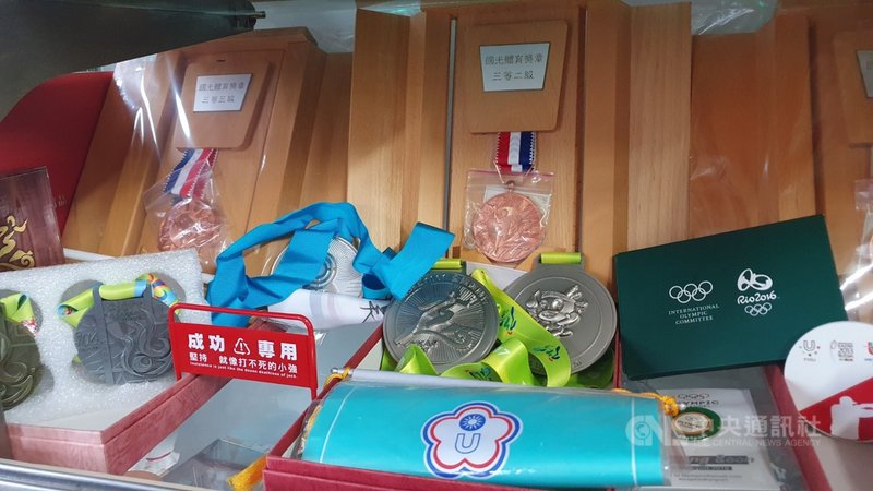 東京奧運射擊項目女子25公尺手槍30日上午進行第2天資格賽(快射),台灣射擊好手吳佳穎父母一早就拿著平板跟手機在高雄前鎮區住家緊跟直播,櫃子內也擺滿許多吳佳穎過去拿下的獎牌與獎章。中央社記者洪學廣攝 110年7月30日
