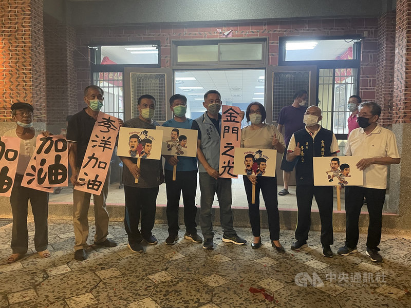 金門籍羽球好手李洋與搭檔王齊麟31日在東京奧運羽球男雙冠軍戰勇奪金牌,金門縣長楊鎮浯(前右4)開心地舉起「金門之光」標語。中央社記者黃慧敏攝 110年7月31日