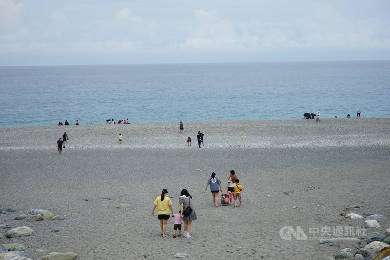 國內疫情警戒降為2級首個假日,花蓮七星潭風景區出現旅遊人潮,不少民眾在沙灘觀海。中央社記者張祈攝 110年7月31日