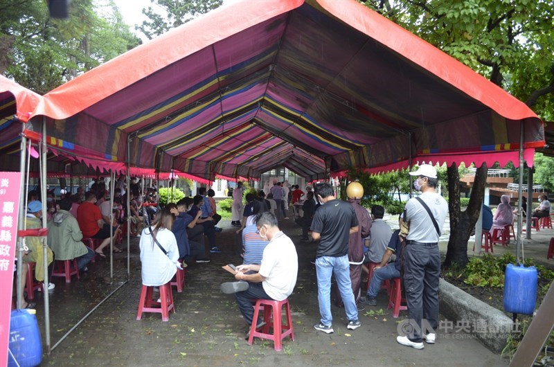 嘉義縣某工廠爆發群聚染疫事件,開設擴大篩檢站,31 日在水上鄉南靖國小靖西分校進行篩檢作業,一早就湧入上百人排隊等待篩檢。中央社記者蔡智明攝 110年7月31日