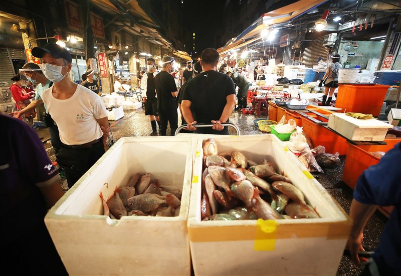 基隆崁仔頂魚市是北台灣重要海產交易市場,採買業者戴起面罩與口罩在魚市裡穿梭找尋魚貨。