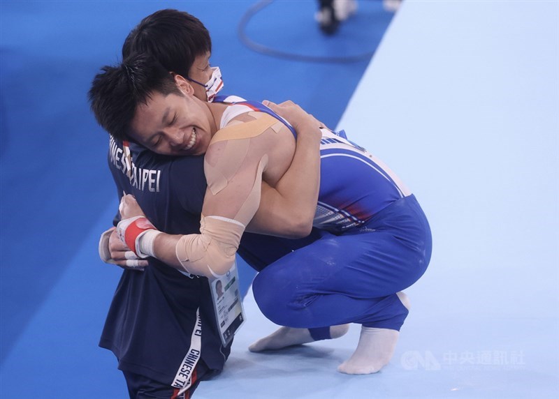 東京奧運體操男子鞍馬單項決賽1日晚間登場，台灣好手李智凱（右）成功展現拿手「湯瑪士迴旋」，精彩完成一連串動作，並一掃陰影完美落地，他在下馬後開心與場邊教練相擁。中央社記者吳家昇攝 110年8月1日