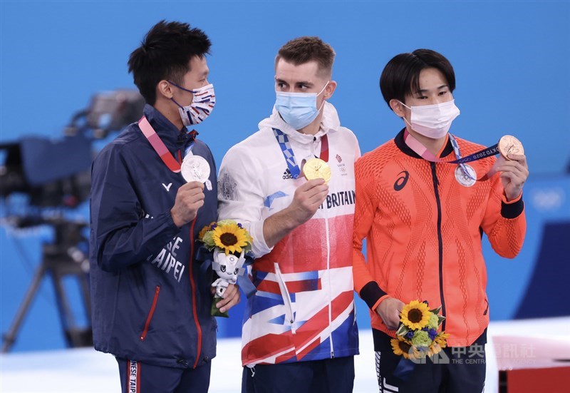 東京奧運體操男子鞍馬單項決賽1日晚間登場，英國名將懷特洛克（Max Whitlock）（中）第一個上場就拿下超高分，台灣「鞍馬王子」李智凱（左）「湯瑪士迴旋」的完美弧度則搶下銀牌，銅牌則由地主日本好手萱和磨（右）留下。中央社記者吳家昇攝 110年8月1日