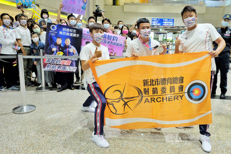 台灣射箭好手出征東京奧運戰場，1日結束所有賽程後光榮返台，來自選手們學校的學弟妹及親友也特別組團到機場接機，除了手持特製海報、布條，大聲喊著「台灣射箭讚讚讚」的口號，也隔著一段距離合照，以行動展現對選手及運動的支持。中央社記者吳睿騏桃園機場攝 110年8月1日