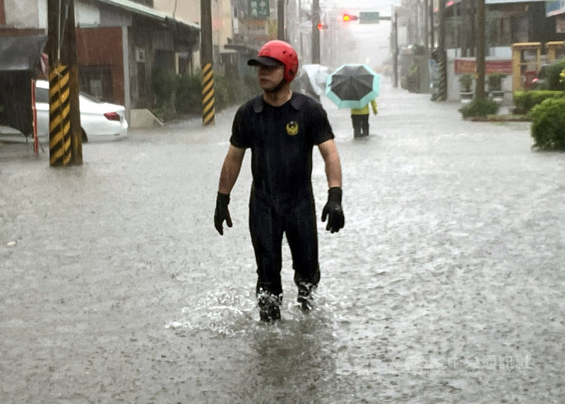 嘉義縣市2日上午降豪雨,新港鄉時雨量達120毫米,新港消防分隊前嚴重積水,消防人員涉水巡視低窪地區救災。(新港消防分隊提供)中央社記者黃國芳傳真 110年8月2日