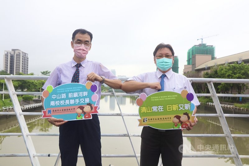 高雄市前鎮、福誠高中兩校校長2日一早跨越前鎮河,完成互換新舊任校長交接。福誠高中校長蘇清山(左)、前鎮高中校長夏日新(右)在這波校長職務中互調,兩人互相擊肘,並接受獻花。(高市教育局提供)中央社記者洪學廣傳真 110年8月2日