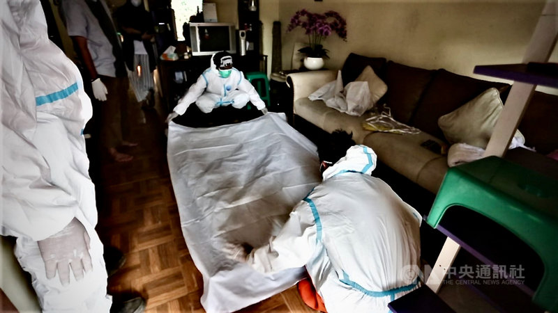 依伊斯蘭教義,人死後的軀體僅以白棉布包覆,不用棺木直接土葬。印尼志工協助家屬以符合防疫的方式安葬染疫死者。圖為志工在死者家裡準備白棉布,攝於7月30日。中央社記者石秀娟茂物攝 110年8月2日