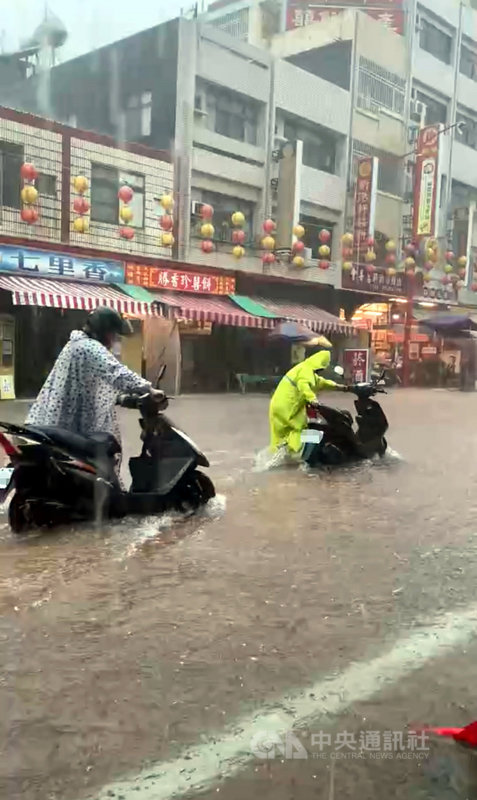 嘉義縣市2日上午降豪雨,新港奉天宮前嚴重積水,機車騎士需下車才能通行。(新港奉天宮提供)中央社記者黃國芳傳真 110年8月2日