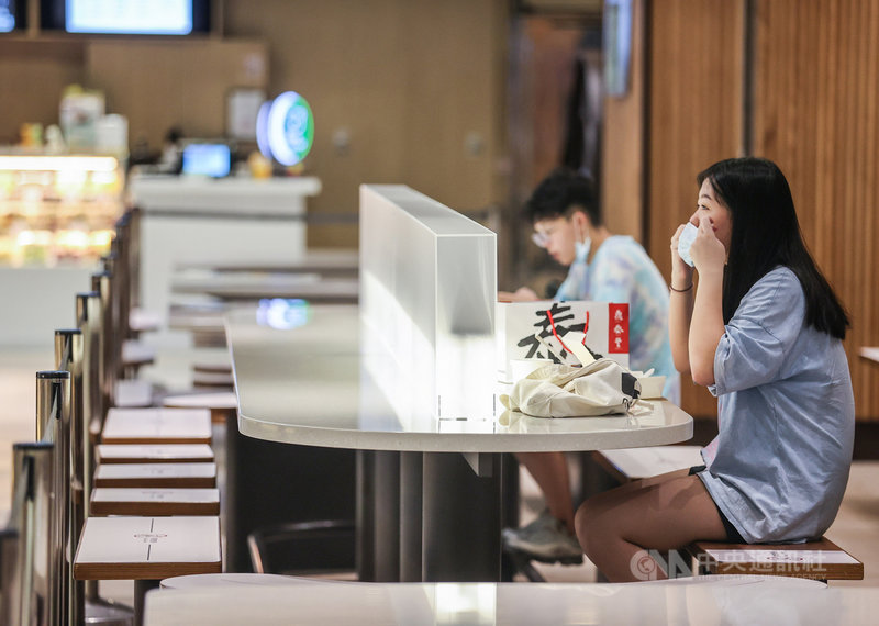 台北101購物中心美食街3日開放民眾內用,業者在桌面設置隔板、並採梅花座維持安全距離,民眾用餐後也配合防疫立刻戴上口罩。中央社記者鄭清元攝 110年8月3日