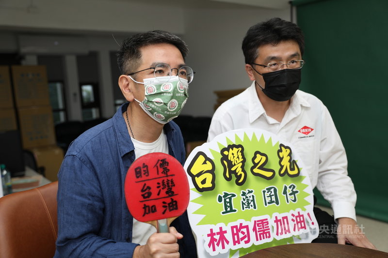 台灣桌球男團3日在東京奧運出賽對戰德國,林昀儒的姑丈林大溢(右)與宜蘭市長江聰淵(左)下午一同守在電視機前觀賞賽事,手持標語加油。(讀者提供)中央社記者王朝鈺傳真 110年8月3日