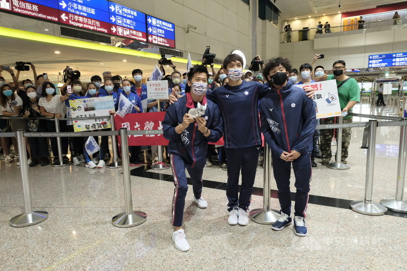 參加東京奧運的體操與拳擊選手3日搭機返台,來自國立體育大學的學弟妹手持特製海報、布條到桃園國際機場接機,大聲呼喊「李智凱讚讚讚」口號,並隔空合照。中央社記者吳睿騏桃園機場攝 110年8月3日