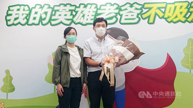 父親節前夕,衛福部國健署5日舉辦「我的英雄老爸不吸菸」記者會,曾有30年菸癮的巫先生(右),為了家人及自己的健康,終於在44歲時戒菸成功,他的女兒(左)出席獻花祝福。中央社記者陳婕翎攝 110年8月5日