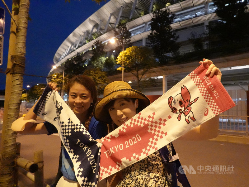 東京奧運8日舉行閉幕式,主場館國立競技場外圍吸引許多民眾駐足欣賞煙火,有些人還帶著奧運紀念布條融入氣氛。中央社記者楊明珠東京攝 110年8月8日