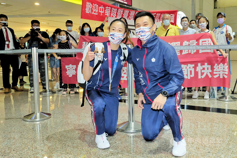 2020東京奧運將落幕，台灣空手道好手文姿云（前左）、王翌達（前右）結束賽程後，8日下午搭機返台，開心與前來接機的親友團合影。中央社記者吳睿騏桃園機場攝 110年8月8日