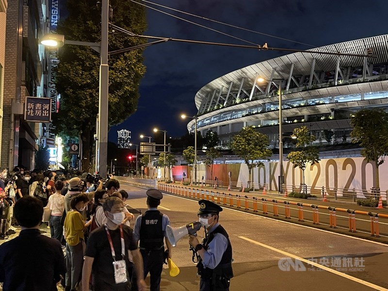 東京奧運8日晚間舉行閉幕式,主場館國立競技場外圍擠滿等待閉幕式的民眾,由於人群擁擠,警察要求民眾離開。中央社記者楊明珠東京攝 110年8月8日