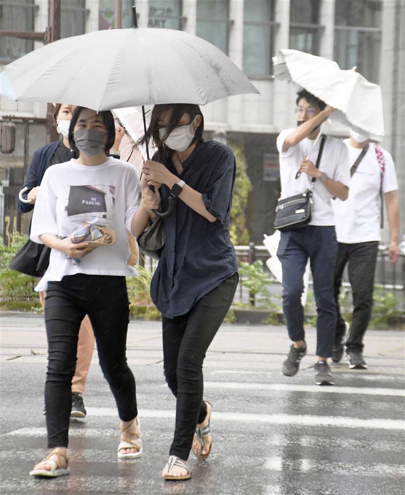 颱風盧碧登陸日本九州地方,截至8日晚間10時30分止,已針對12萬5904個家戶、25萬1055人發出避難指示。圖為8日下午民眾撐傘行經鹿兒島中央站前。(共同社)