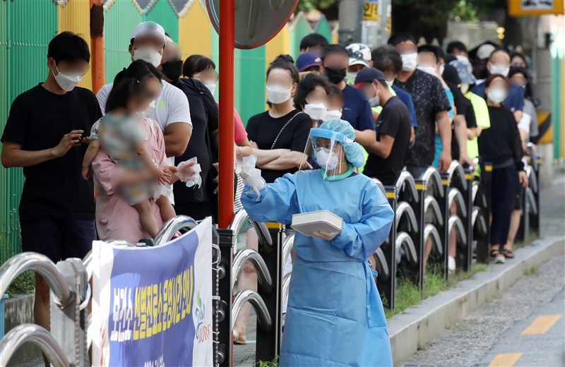 據韓國防疫當局及各地方政府統計,截至10日下午9時,韓國全國新增確診數已達到2021例,刷新單日確診紀錄同時也是首次突破2000例。圖為首爾九老區民眾排隊等待篩檢。(韓聯社)