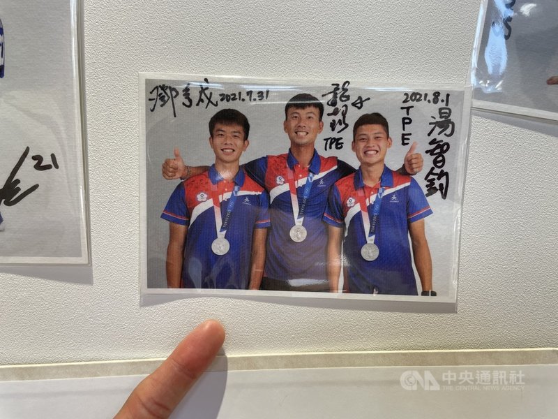 台灣射箭好手鄧宇成(左)入選東京奧運射箭男團,奧運初體驗與隊友合力射下男團銀牌。圖為他在選手村照相館的簽名照。(鄧宇成提供)中央社記者黃巧雯傳真 110年8月11日