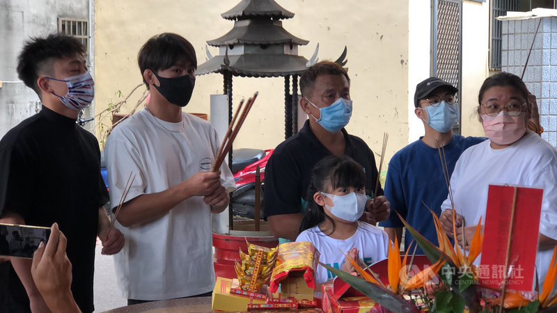 「柔道男神」楊勇緯(左2)東京奧運摘下銀牌後,12日返回台中后里的家,與家人一同到巷口的福德祠拜拜,焚香感謝土地公保佑。中央社記者趙麗妍攝 110年8月12日
