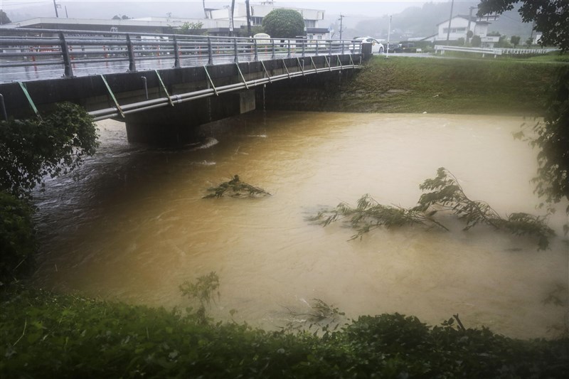 日本因鋒面停滯影響,長崎縣與熊本縣2天累積雨量創新高。圖為12日日本熊本縣和美町河水氾濫。(共同社)