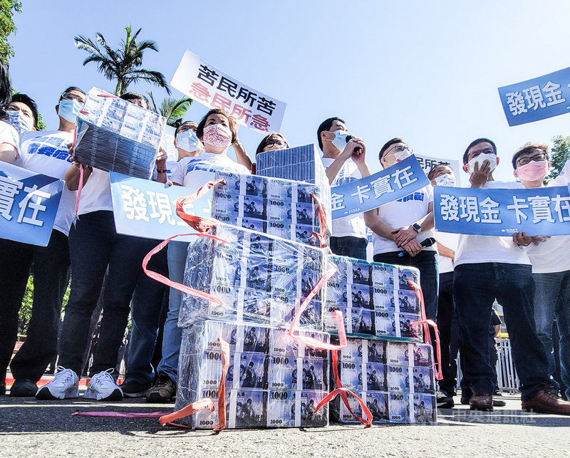 國民黨16日上午在行政院前舉行「紓困發現金」記者會，國民黨立委搬來玩具紙鈔擺放在行政院門口，要求政府苦民所苦、發現金紓困。中央社記者鄭清元攝 110年8月16日