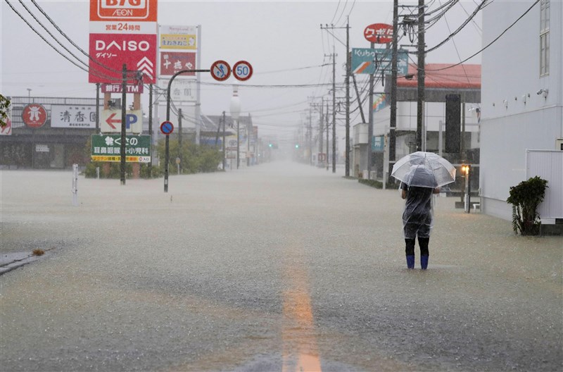 日本九州各地11日起持續大雨,已釀6死4失蹤。圖為14日九州佐賀縣大雨造成道路淹水。(共同社)
