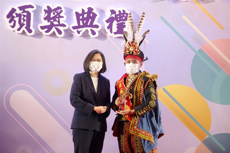 參演公視戲劇「斯卡羅」的查馬克.法拉屋樂19日晚間病逝。民進黨立委伍麗華表示,查馬克支撐到兒子樂可艾(右)北上領總統教育獎後才辭世。樂可艾20日在台北從總統蔡英文(左)手中接過獎項,隨後迅速啟程返鄉。(教育部提供)中央社記者陳至中台北傳真 110年8月20日